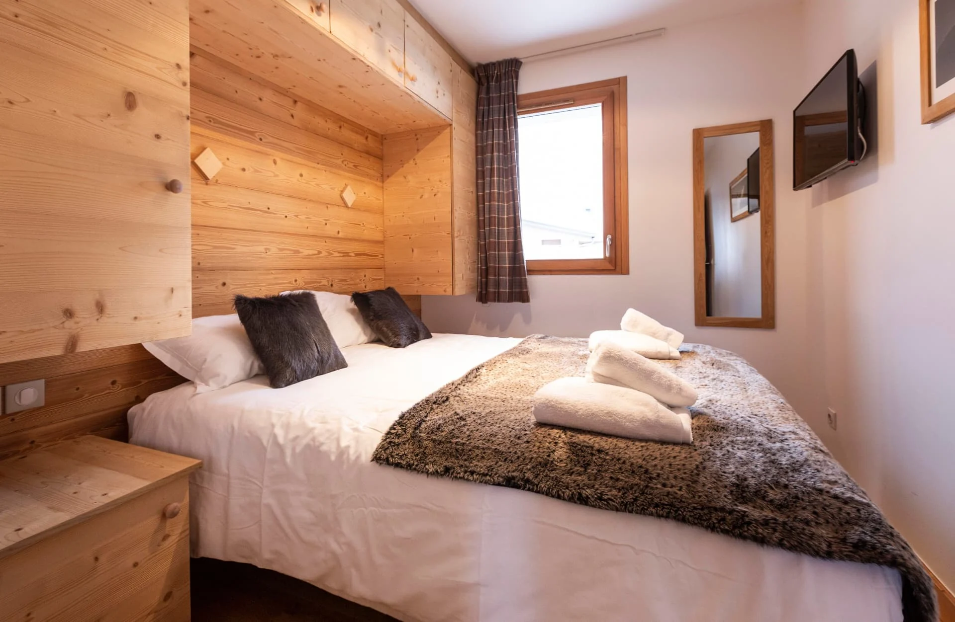Chambre avec lit double de l'appartement Primavera habillée de vieux bois