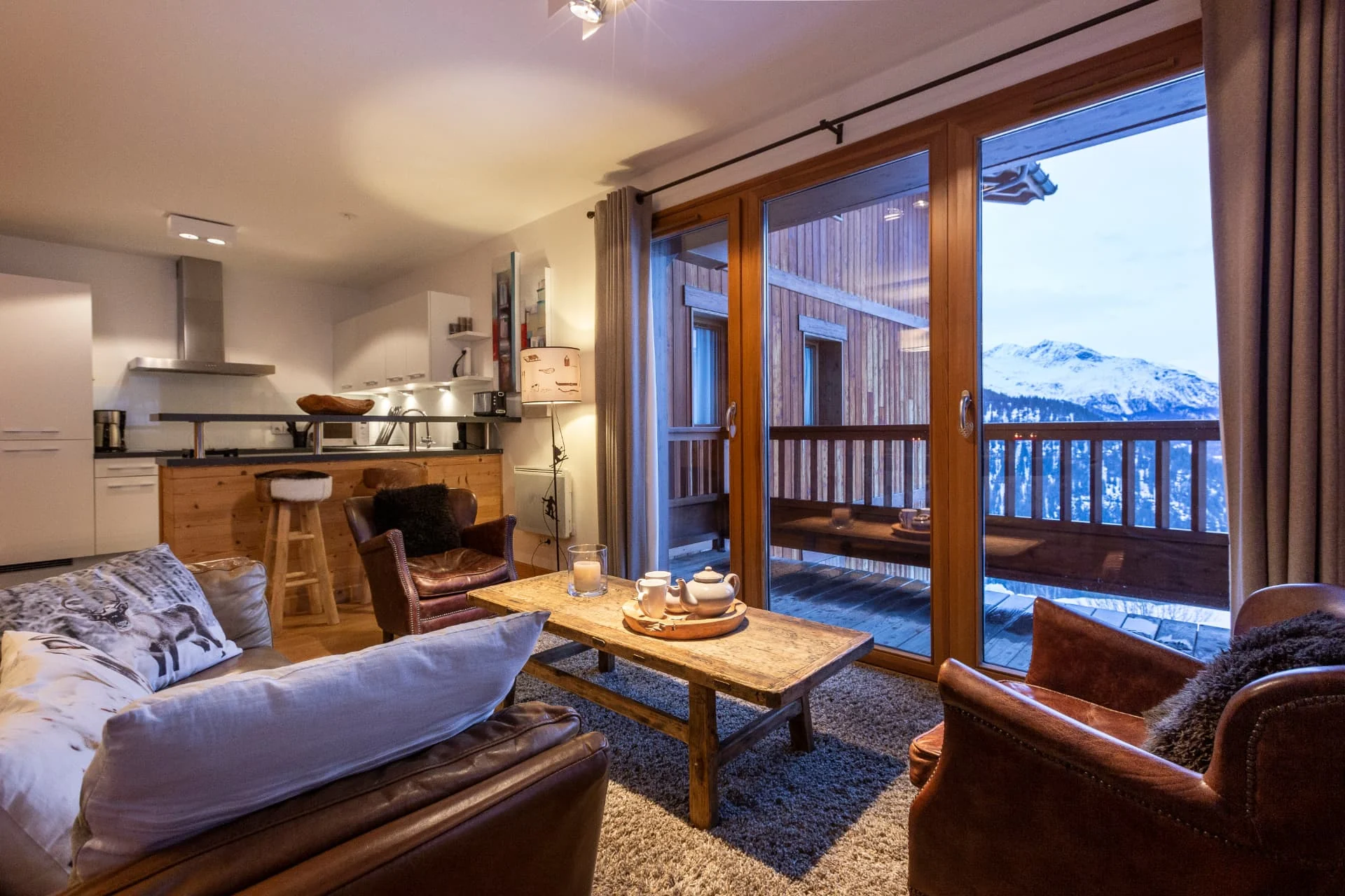 Salon de l'appartement Gélinotte ouvert sur le balcon et la vue montagne