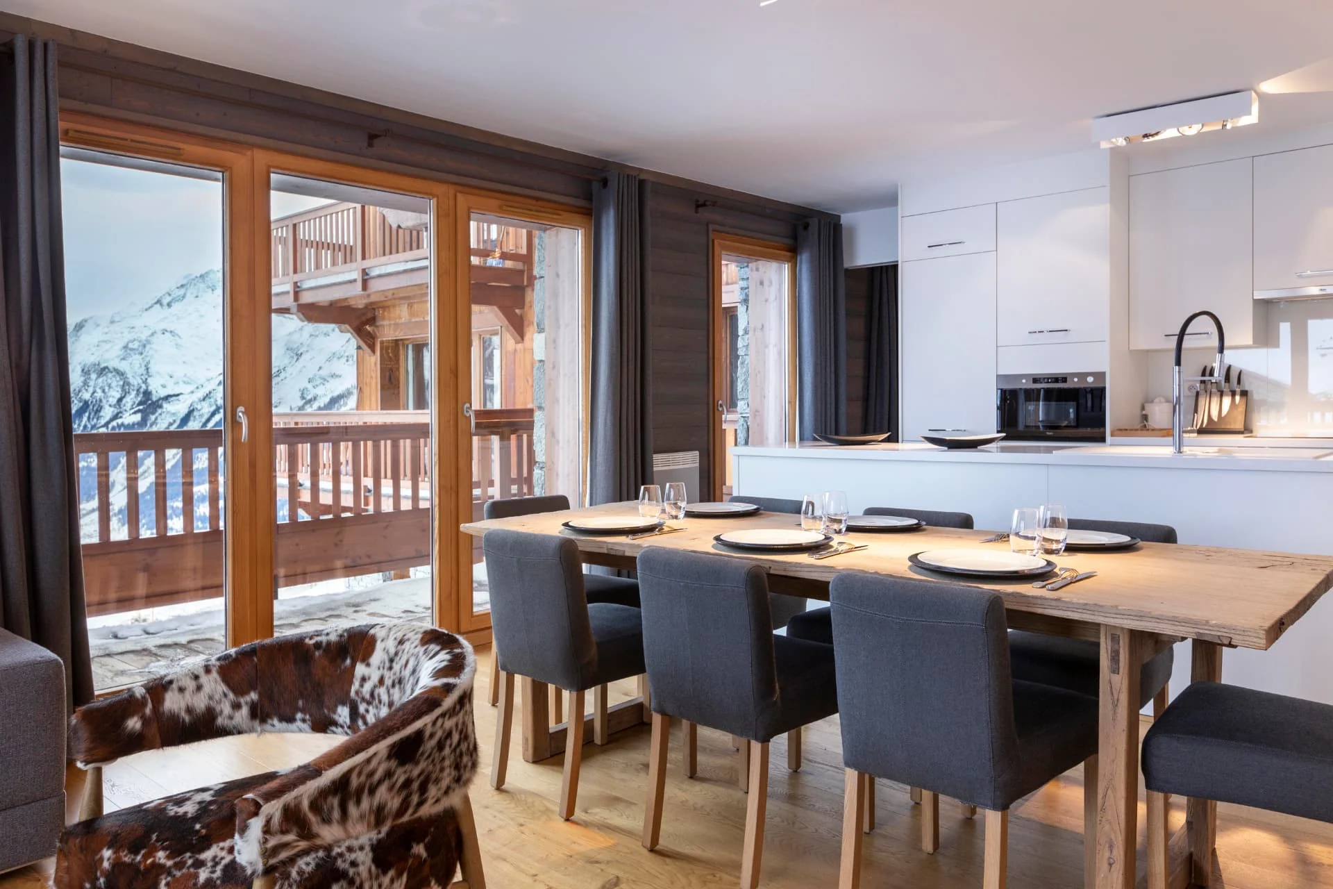 Salle à manger de l'appartement Chamois devant la baie vitrée et la vue montagne