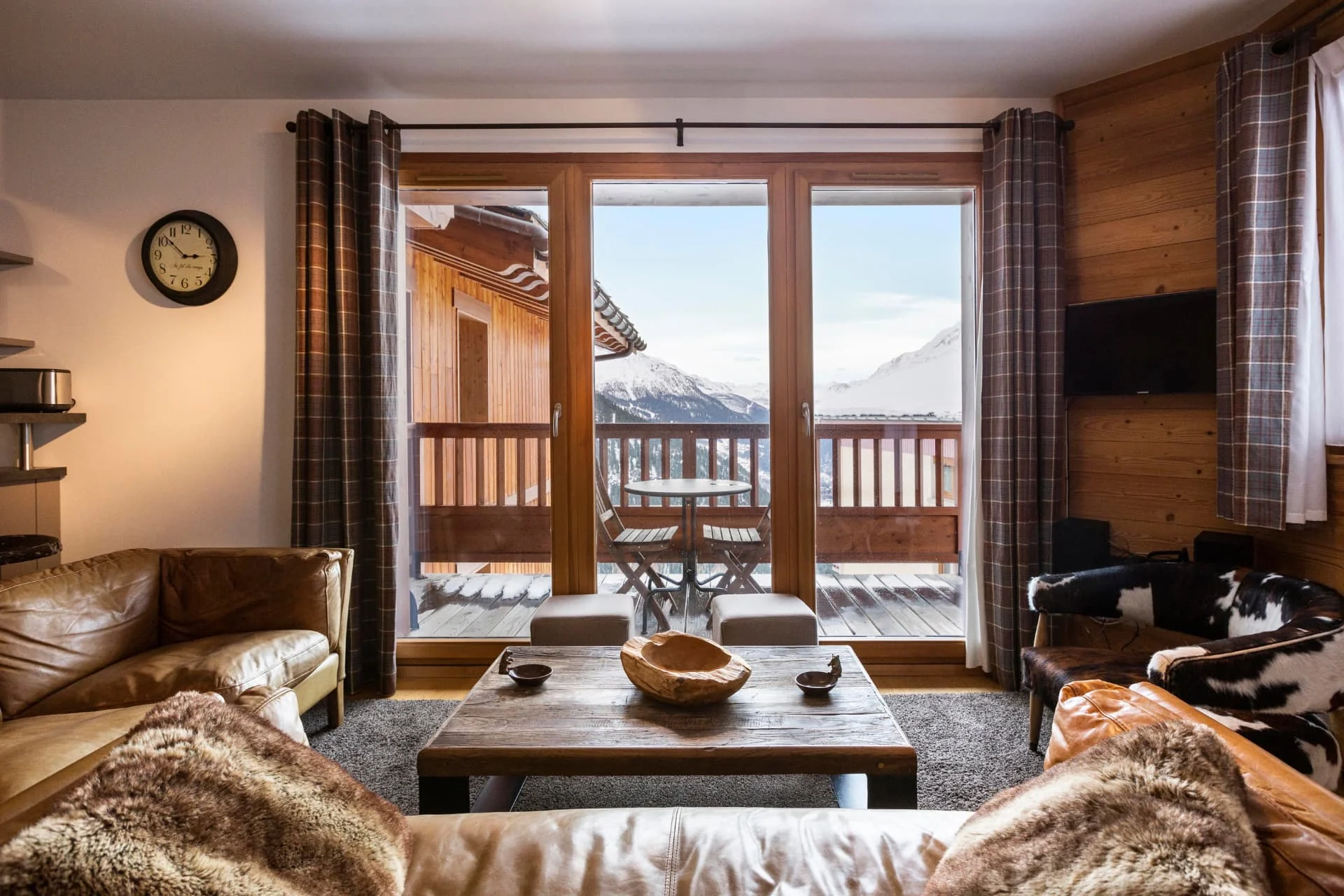 Salon de l'appartement Roc Noir ouvert sur la terrasse en L et la vue sur la Tarentaise