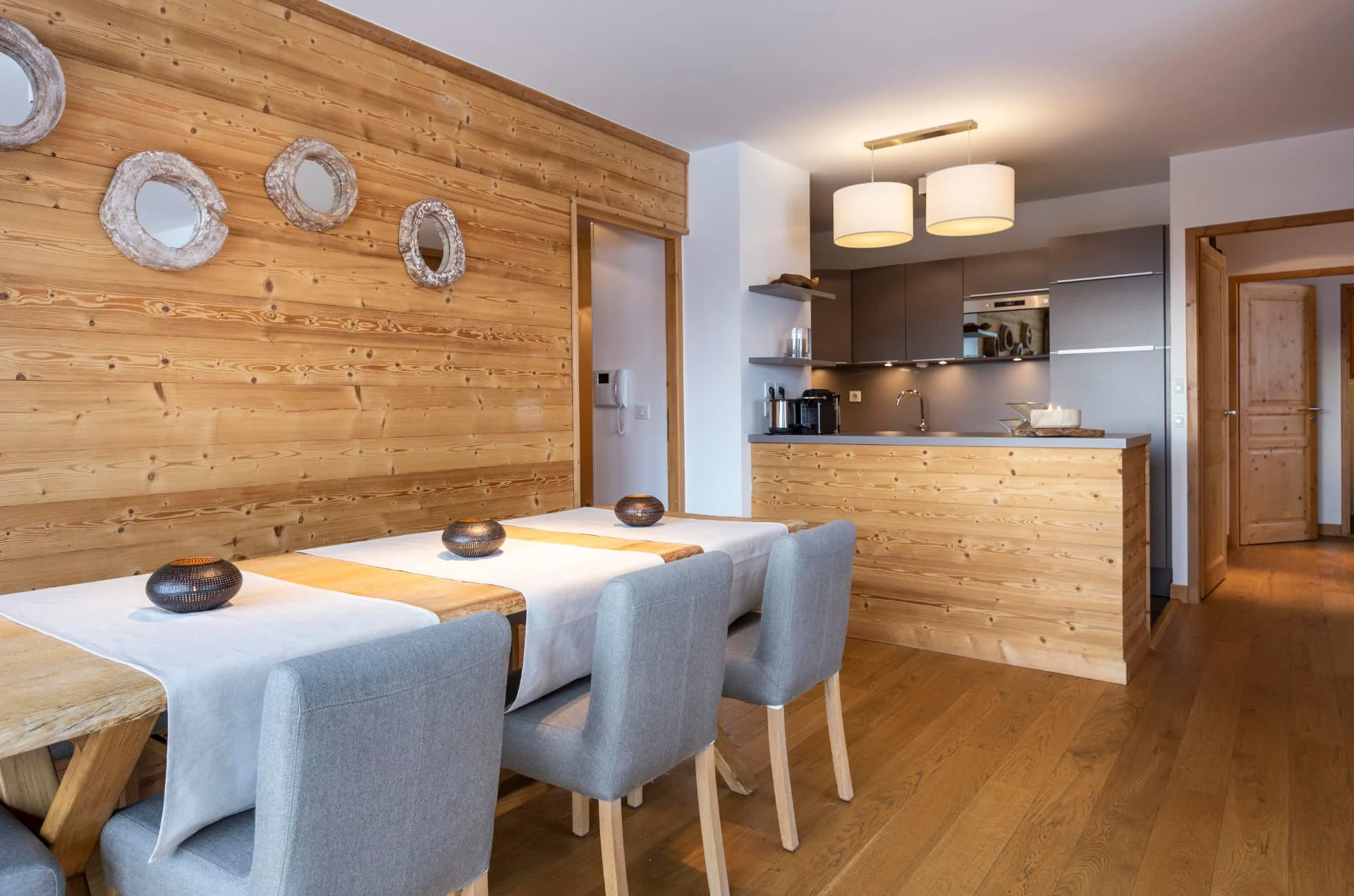 Salle à manger de l'appartement Lauzes ouverte sur la cuisine équipée, boiseries en vieux bois