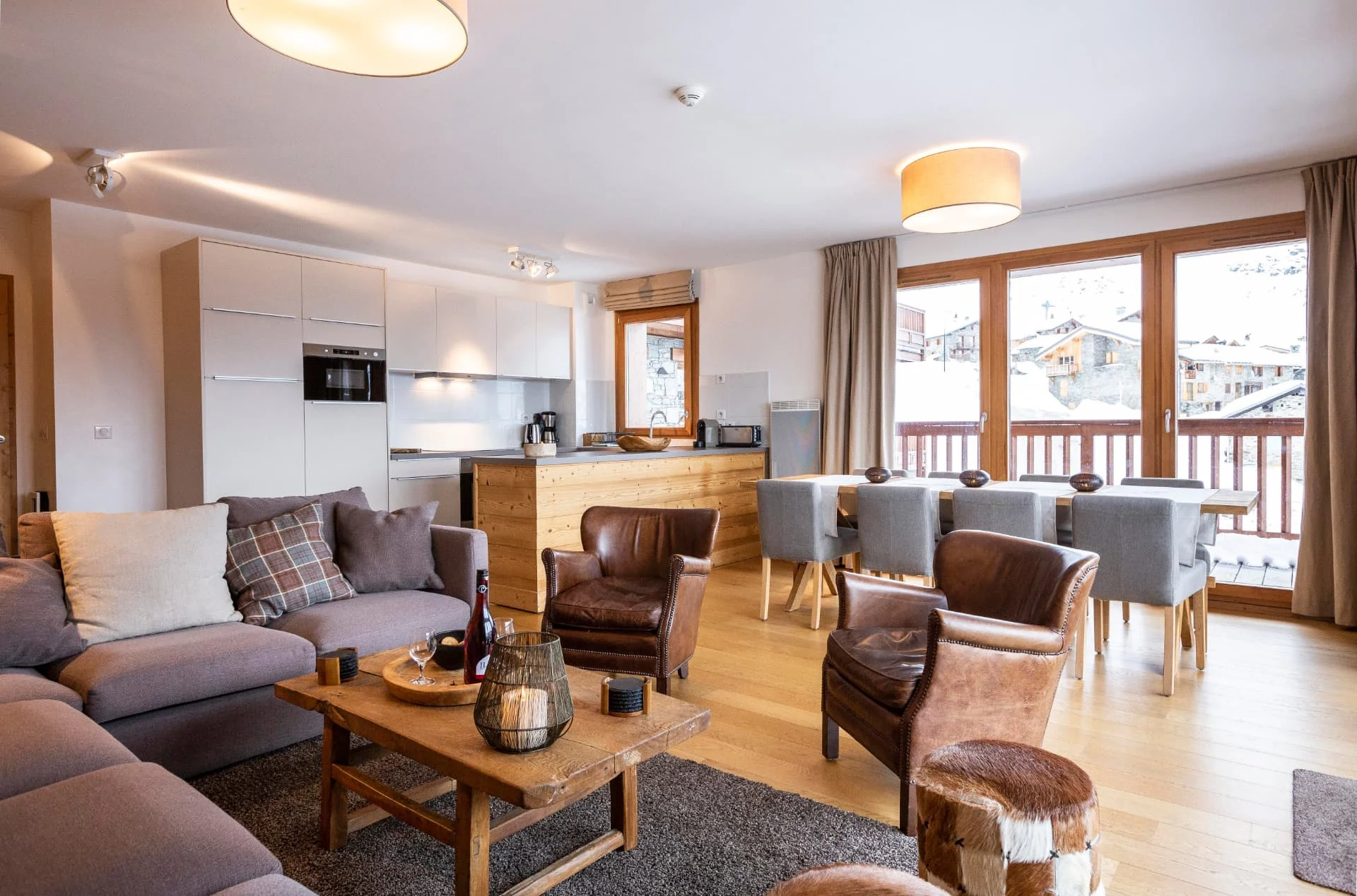 Salon de l'appartement Lièvre Blanc et ses baies vitrées ouvertes sur la terrasse plein sud