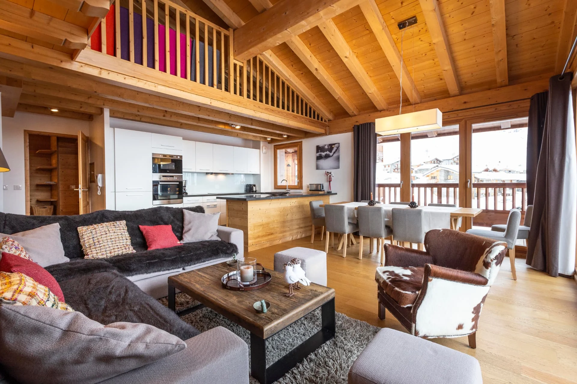 Séjour de l'appartement San Bernardo avec cuisine ouverte et mezzanine sous charpente apparente