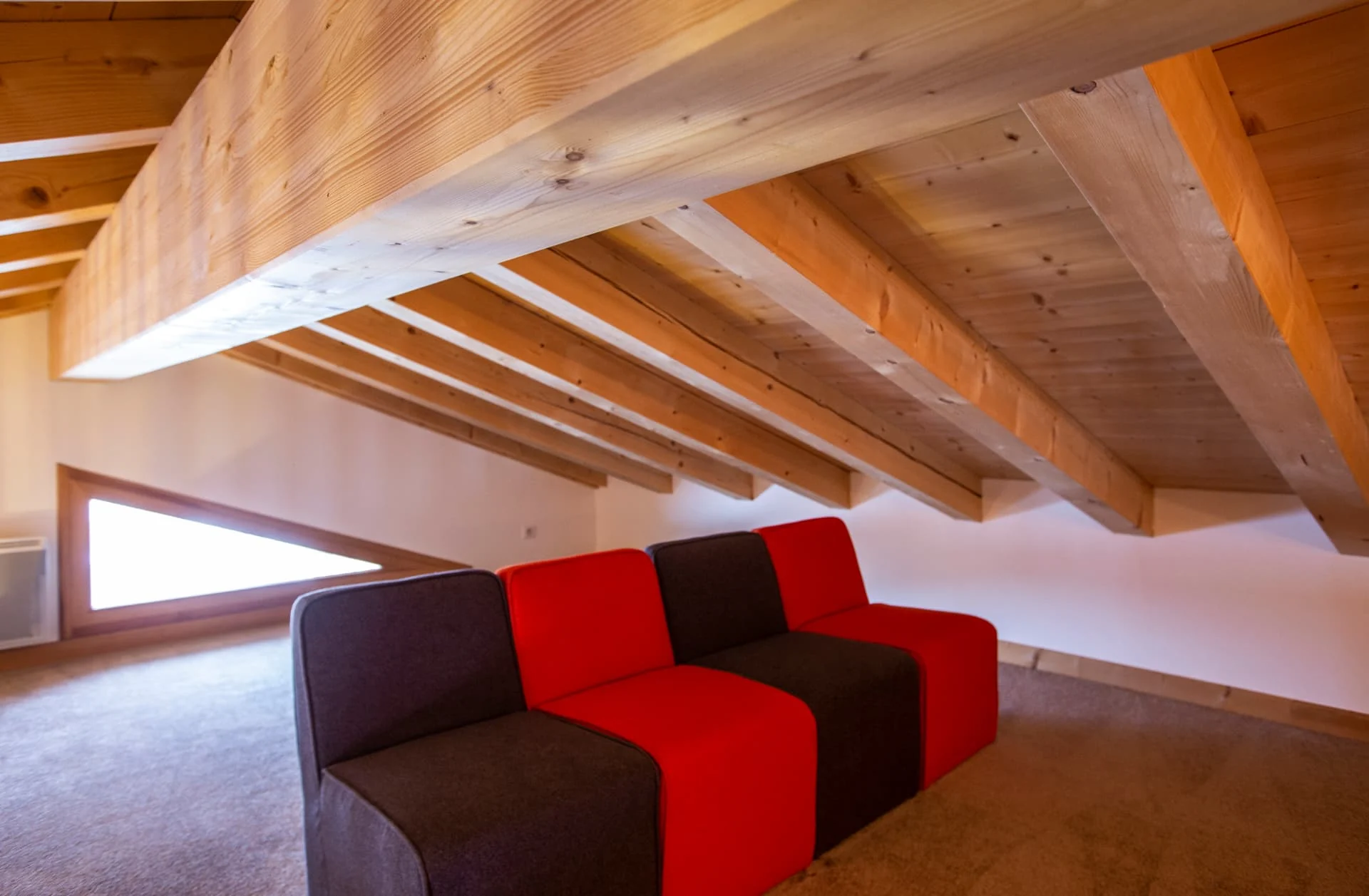 Mezzanine de l'appartement Belvédère aménagée en salon TV sous les poutres