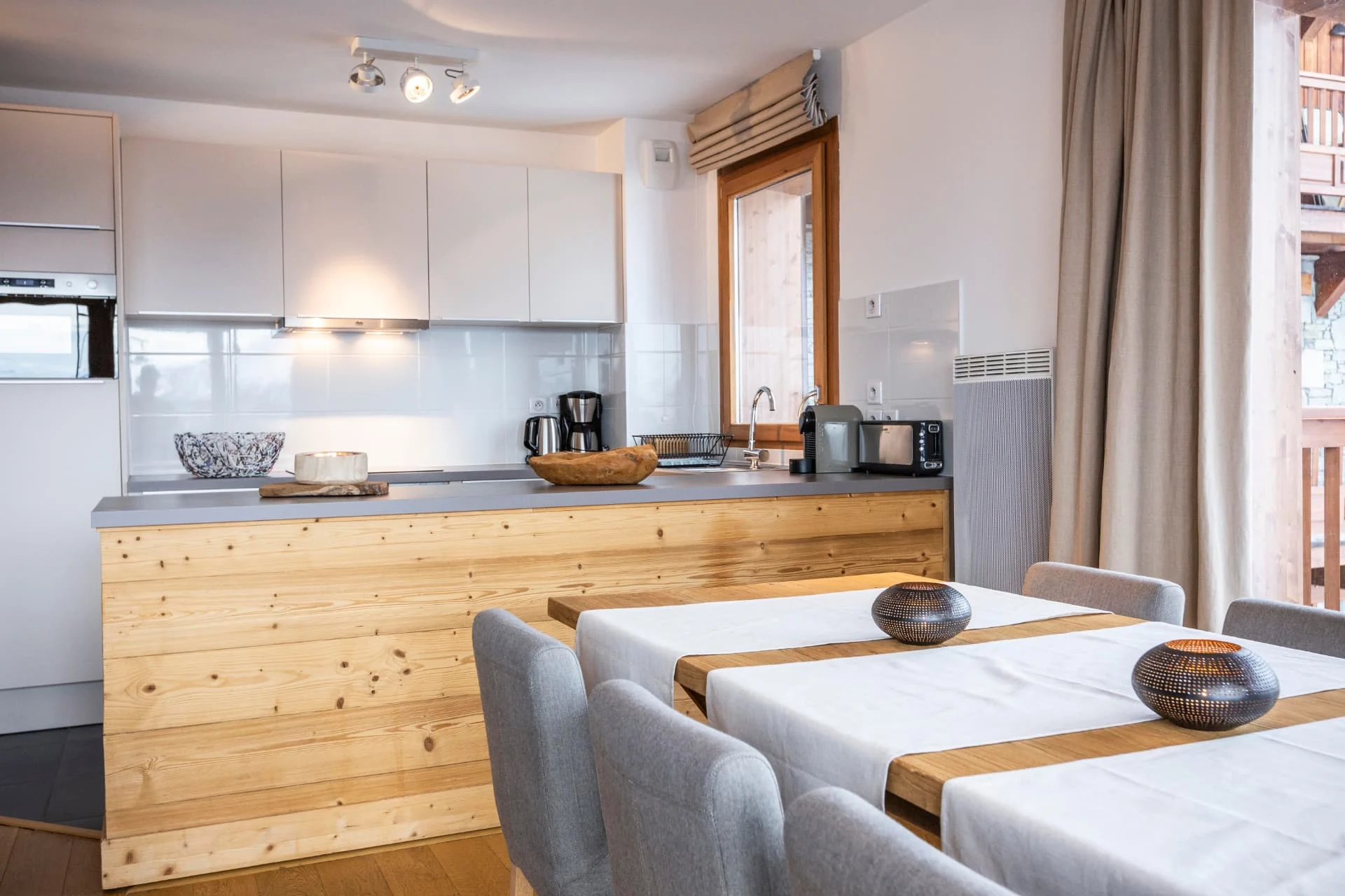 Cuisine entièrement équipée et table dressée de l'appartement Lièvre Blanc