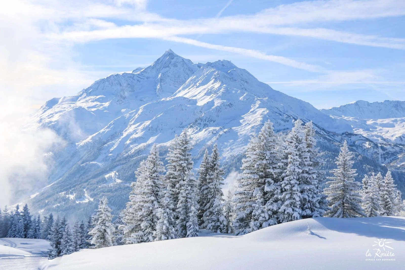 Paysage hivernal de l'Espace San Bernardo, forêts enneigées et sommets du massif