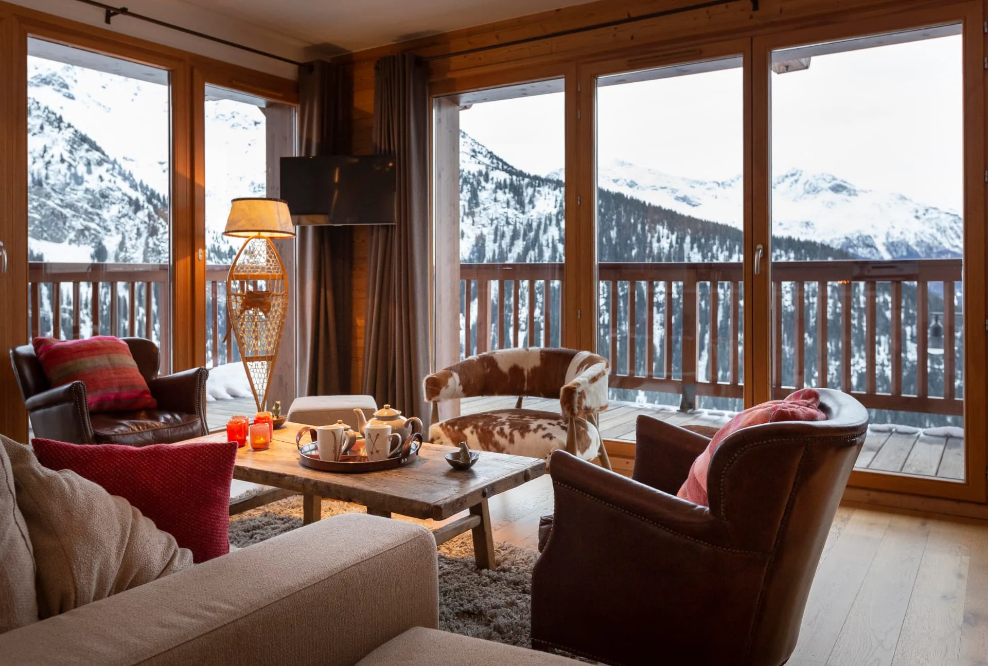 Salon de l'appartement Primavera et ses baies vitrées ouvertes sur les sommets enneigés