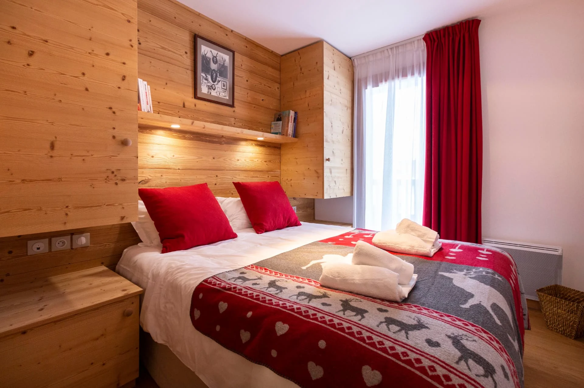 Chambre avec lit double et tête de lit en bois de l'appartement Roc Noir