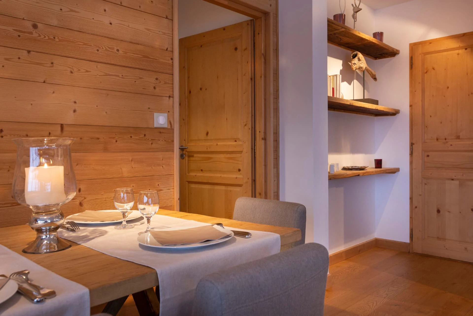 Table dressée de l'appartement Primavera devant un mur en vieux bois