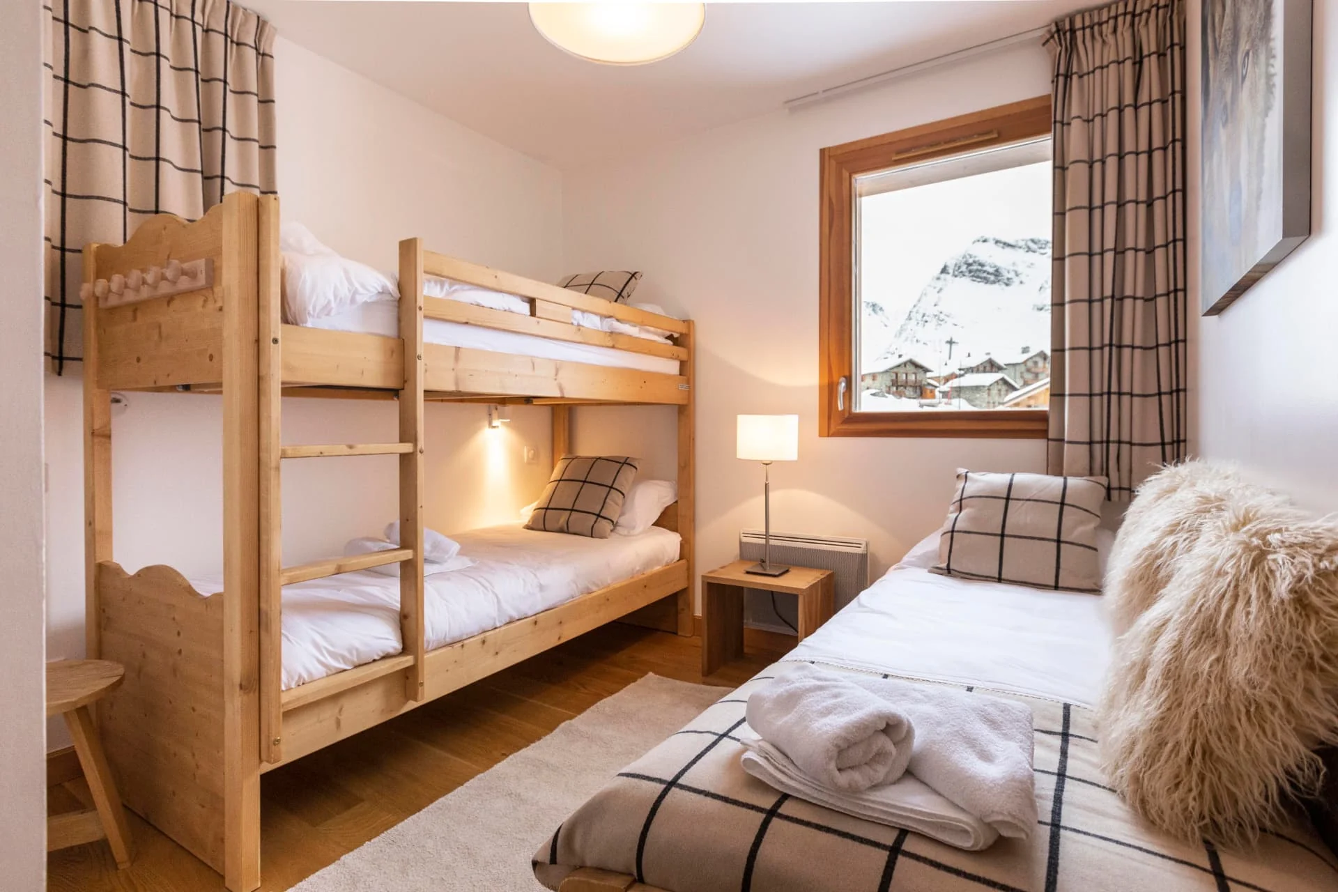Chambre de l'appartement Lauzes avec lits superposés et lit simple, vue sur les Eucherts