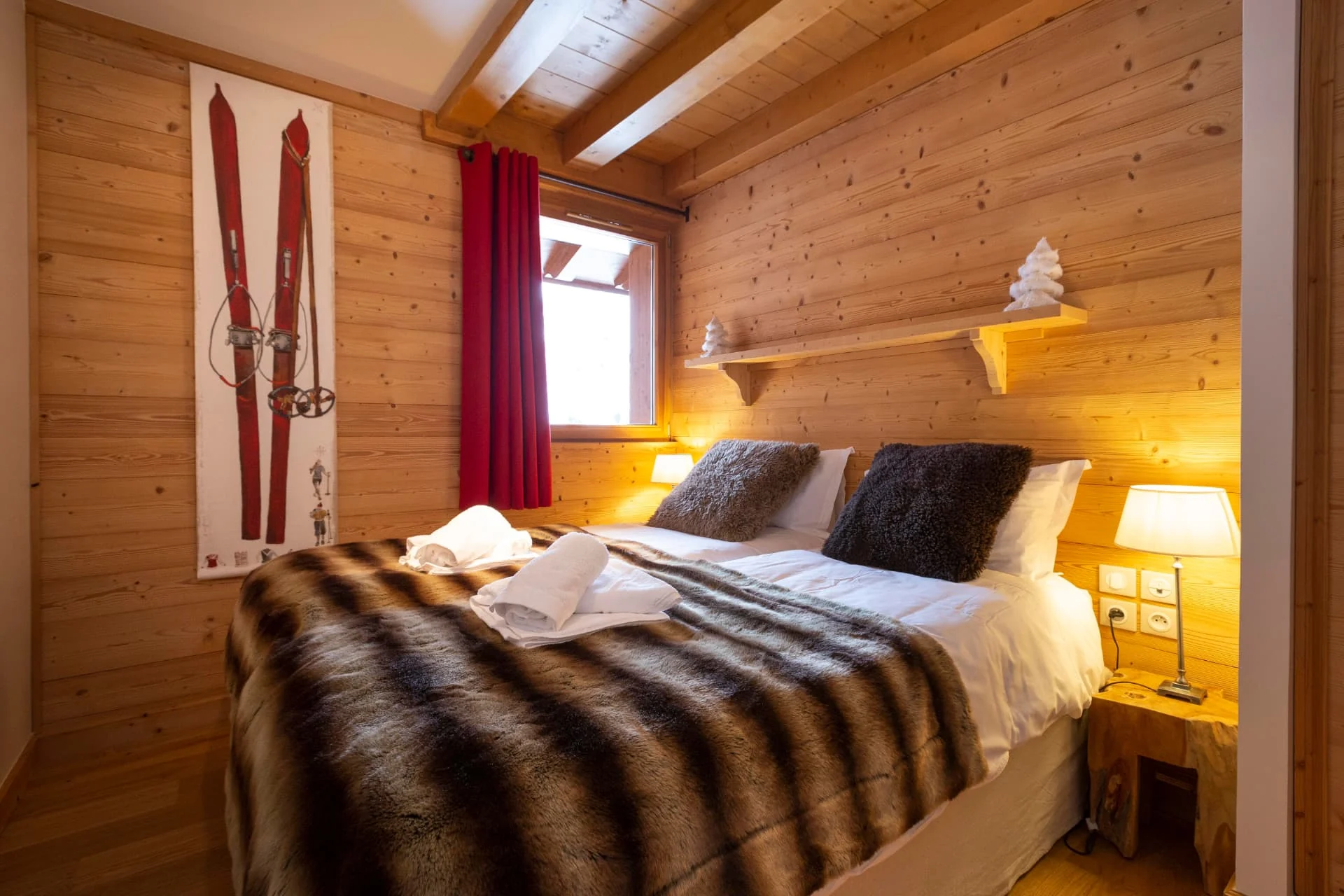 Chambre de l'appartement San Bernardo avec lit double, boiseries et affiche de skis anciens