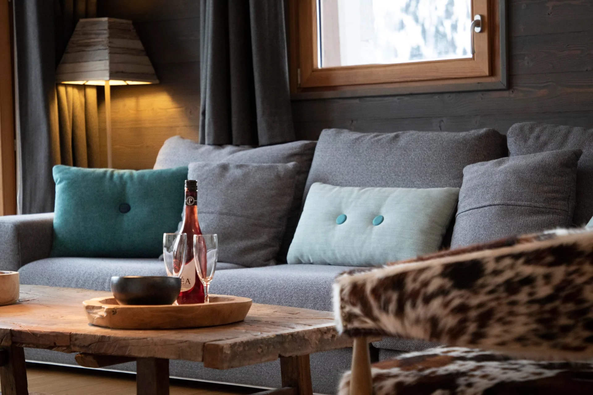 Salon de l'appartement Chamois avec canapé et table basse en vieux bois