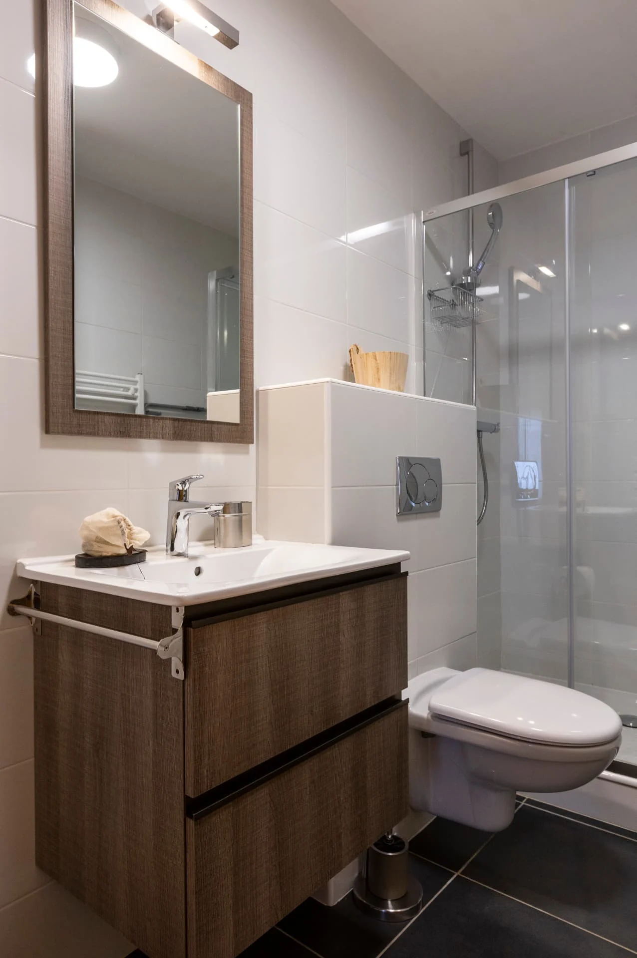 Salle de douche de l'appartement Mouflon avec vasque, meuble en bois et cabine vitrée