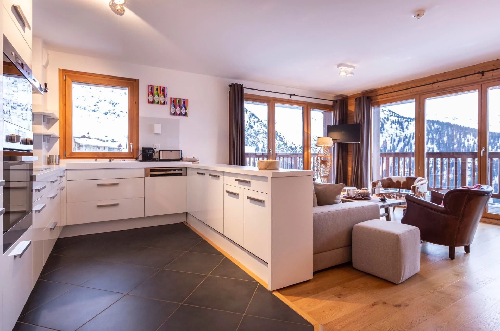 Cuisine entièrement équipée ouverte sur le salon de l'appartement Primavera avec vue sur les montagnes