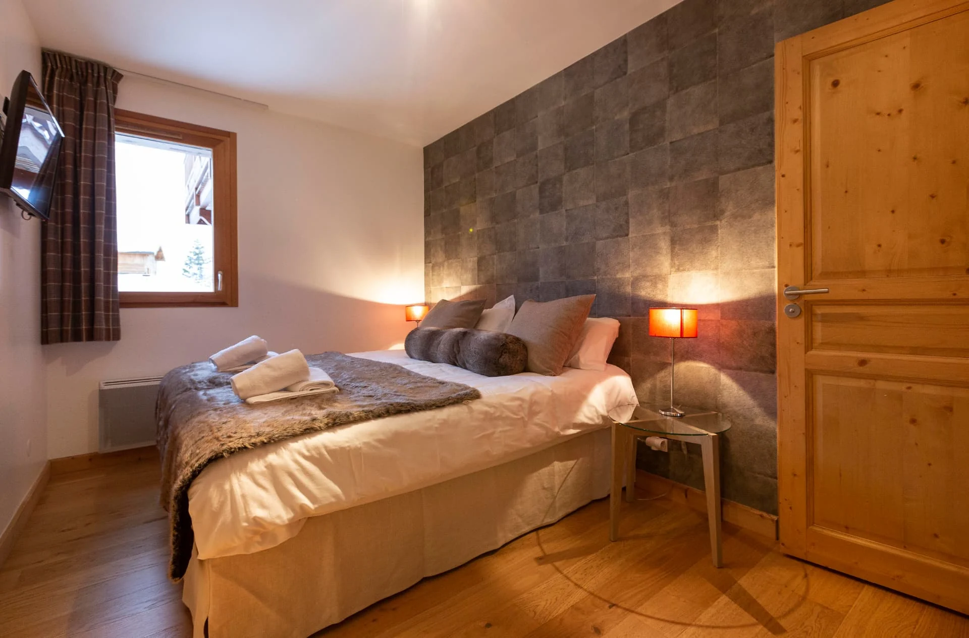 Chambre avec lit double et tête de lit en cuir de l'appartement Primavera