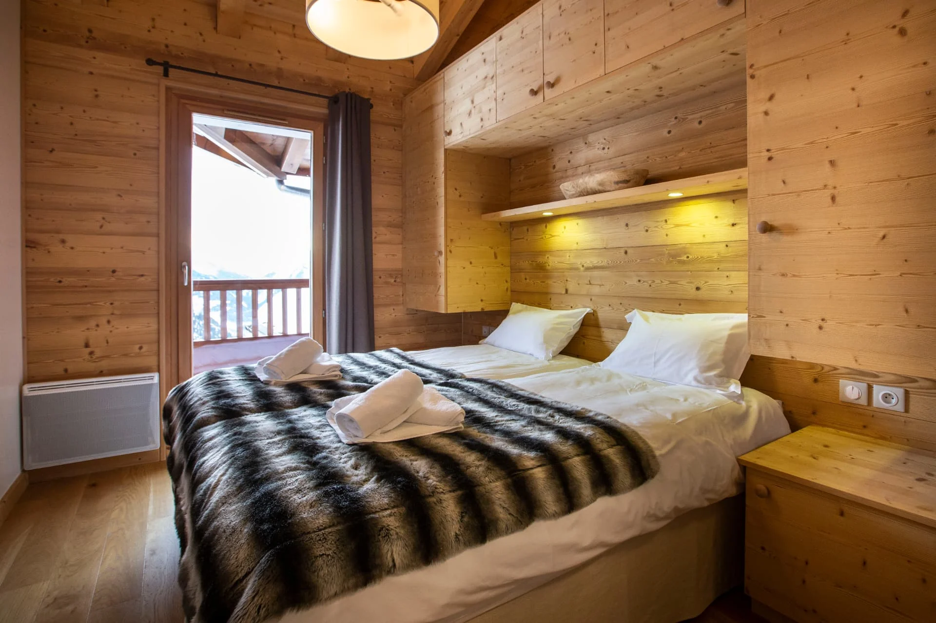 Chambre avec lits jumeaux de l'appartement Bellecombe ouverte sur le balcon