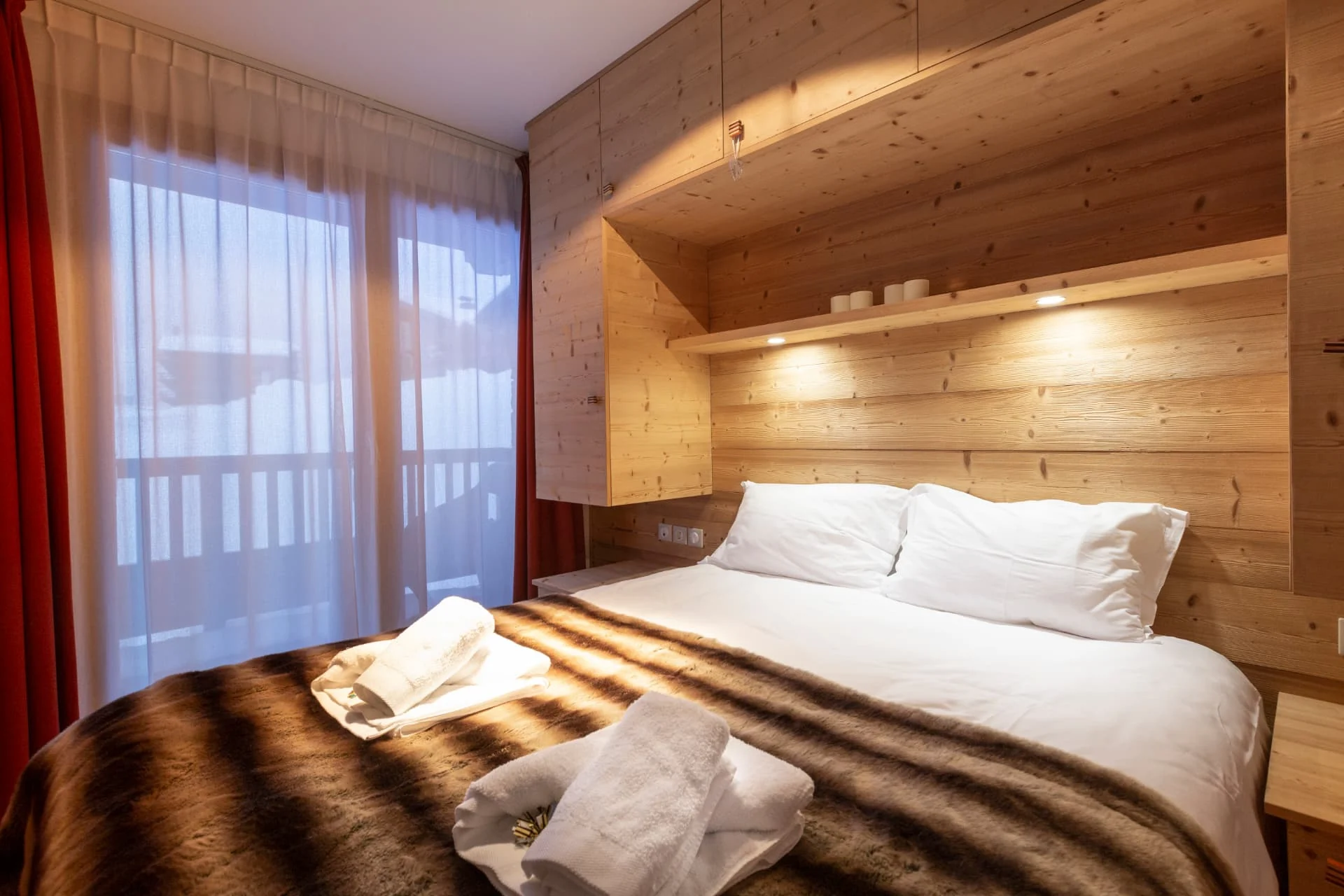 Chambre avec lit double de l'appartement Gélinotte ouverte sur la vue montagne