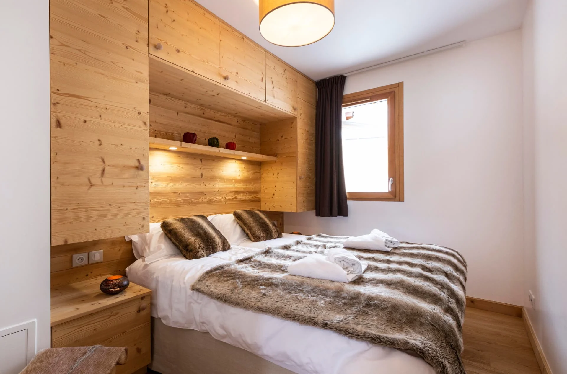 Chambre de l'appartement Lièvre Blanc avec lit double et tête de lit en vieux bois