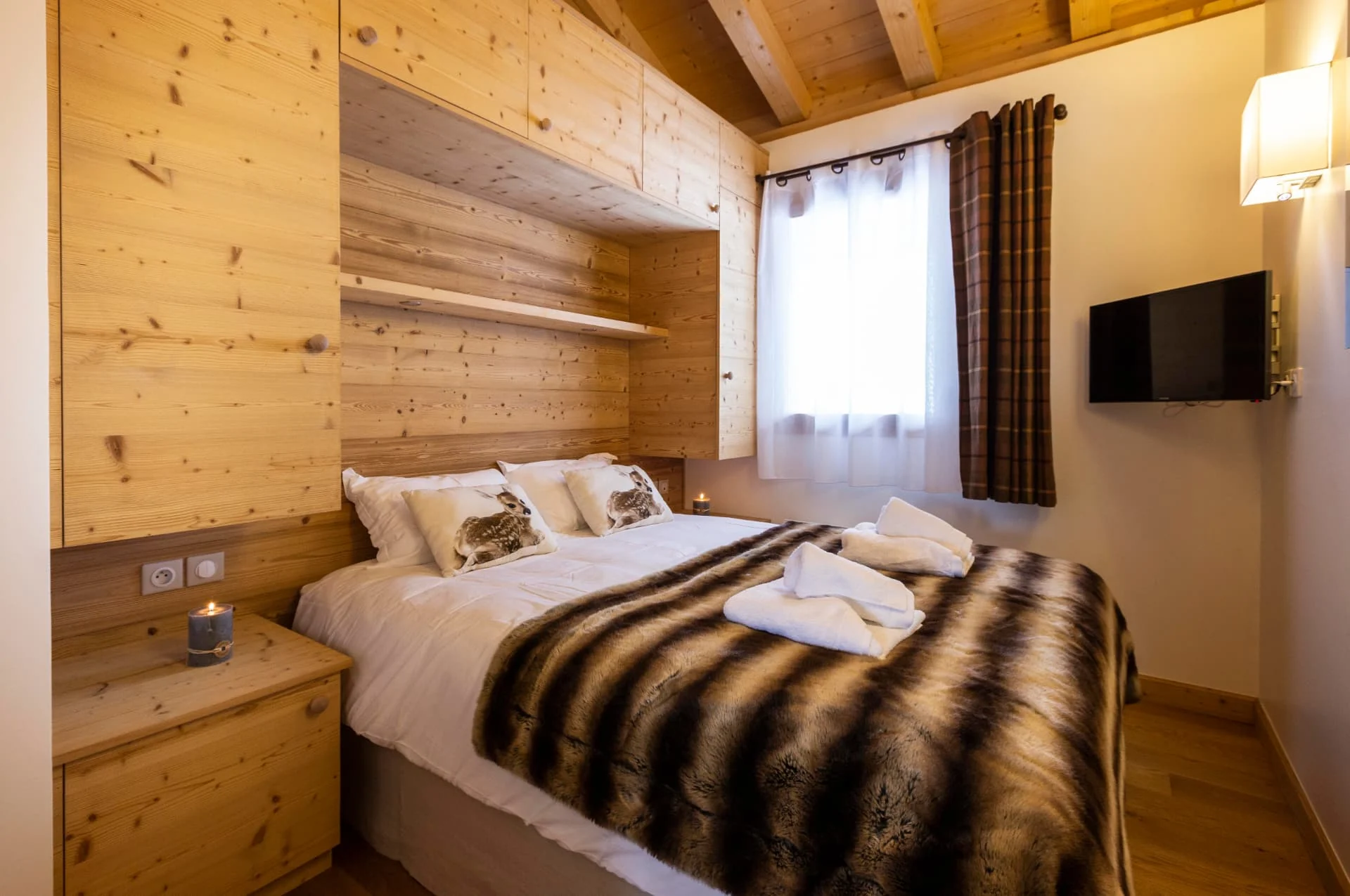 Chambre de l'appartement San Bernardo avec tête de lit en vieux bois et télévision