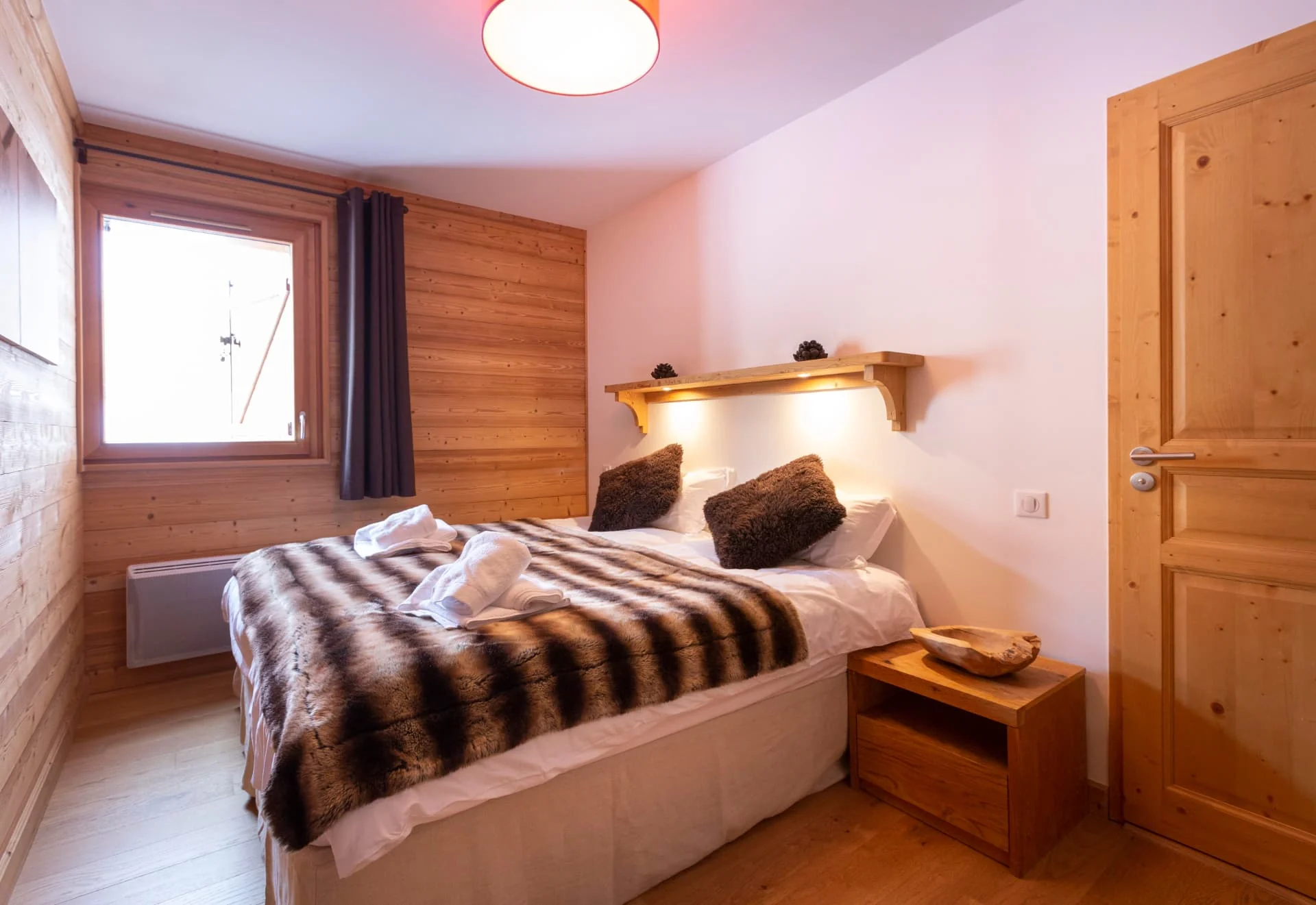 Chambre avec lit double de l'appartement Lièvre Blanc habillée de vieux bois