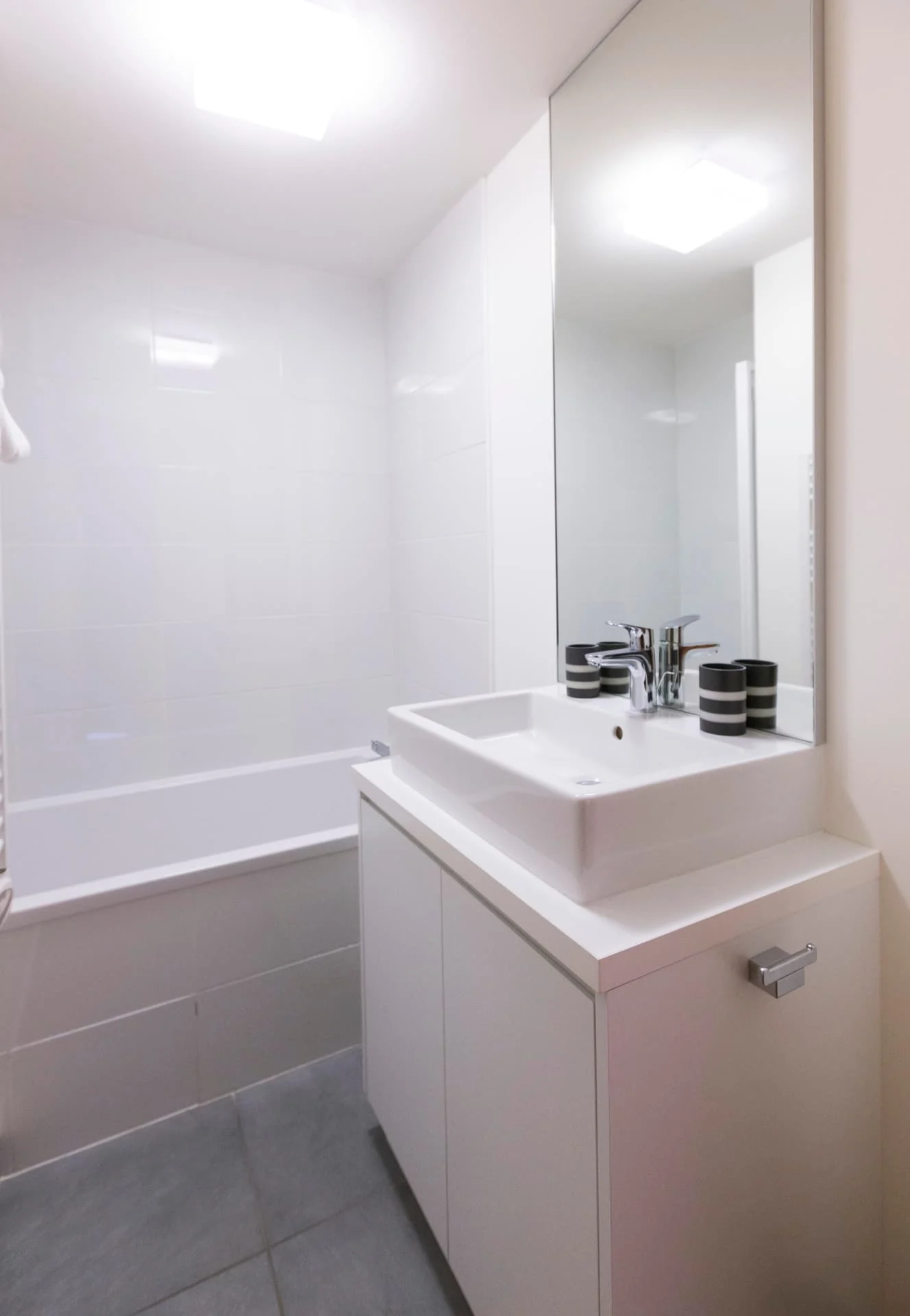 Salle de bain de l'appartement Chamois avec baignoire et vasque blanche