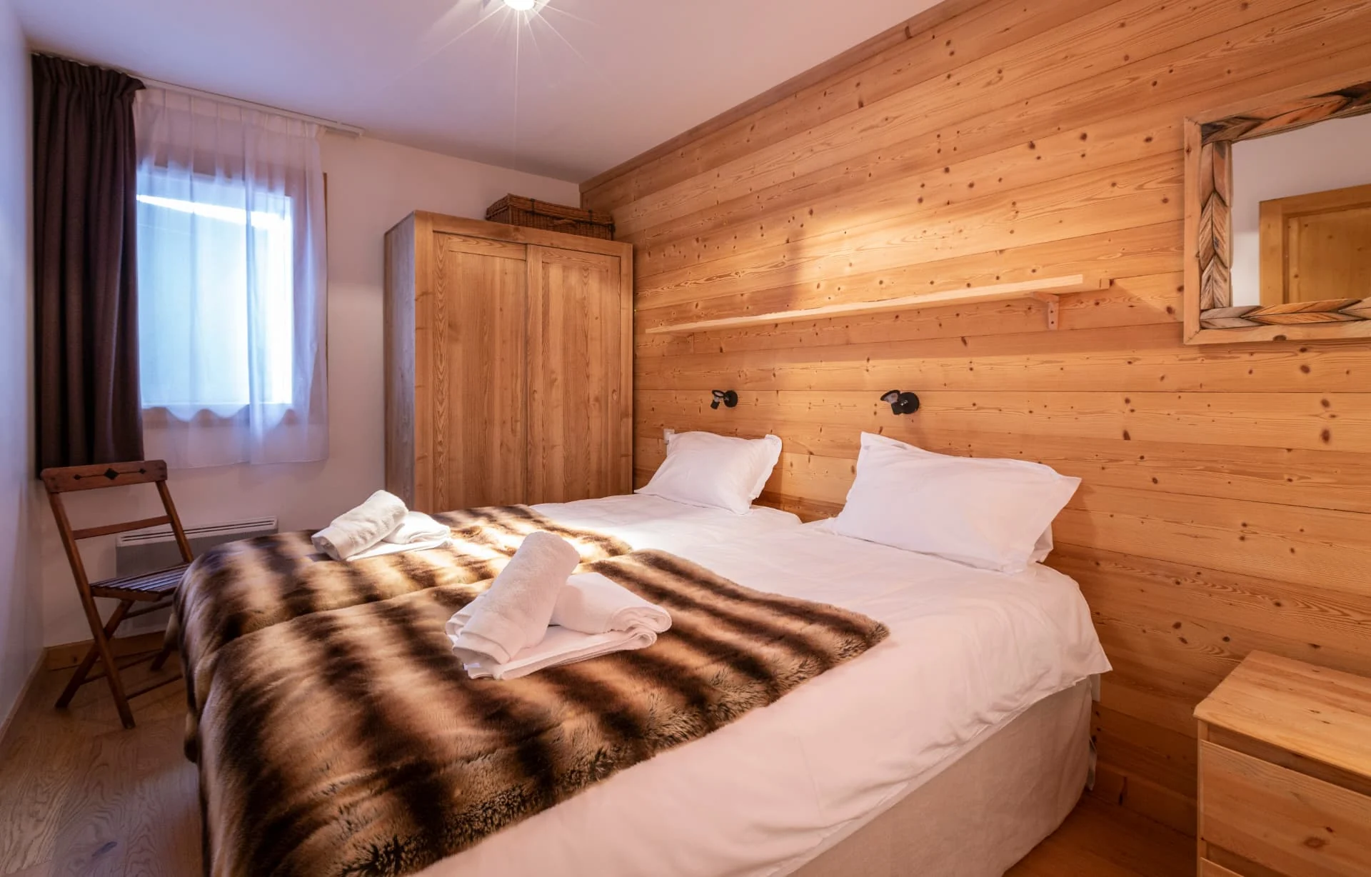 Chambre avec lit double de l'appartement Mouflon habillée de bois clair