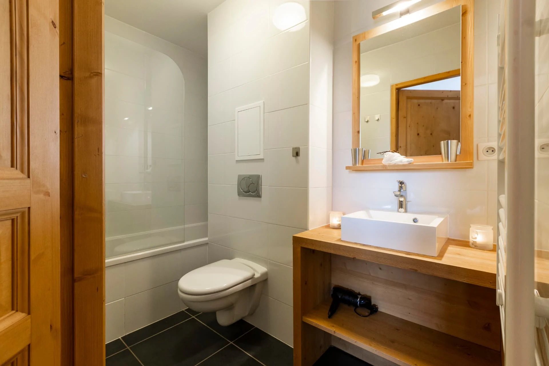 Salle de bain de l'appartement Lauzes avec baignoire, vasque et plan en vieux bois