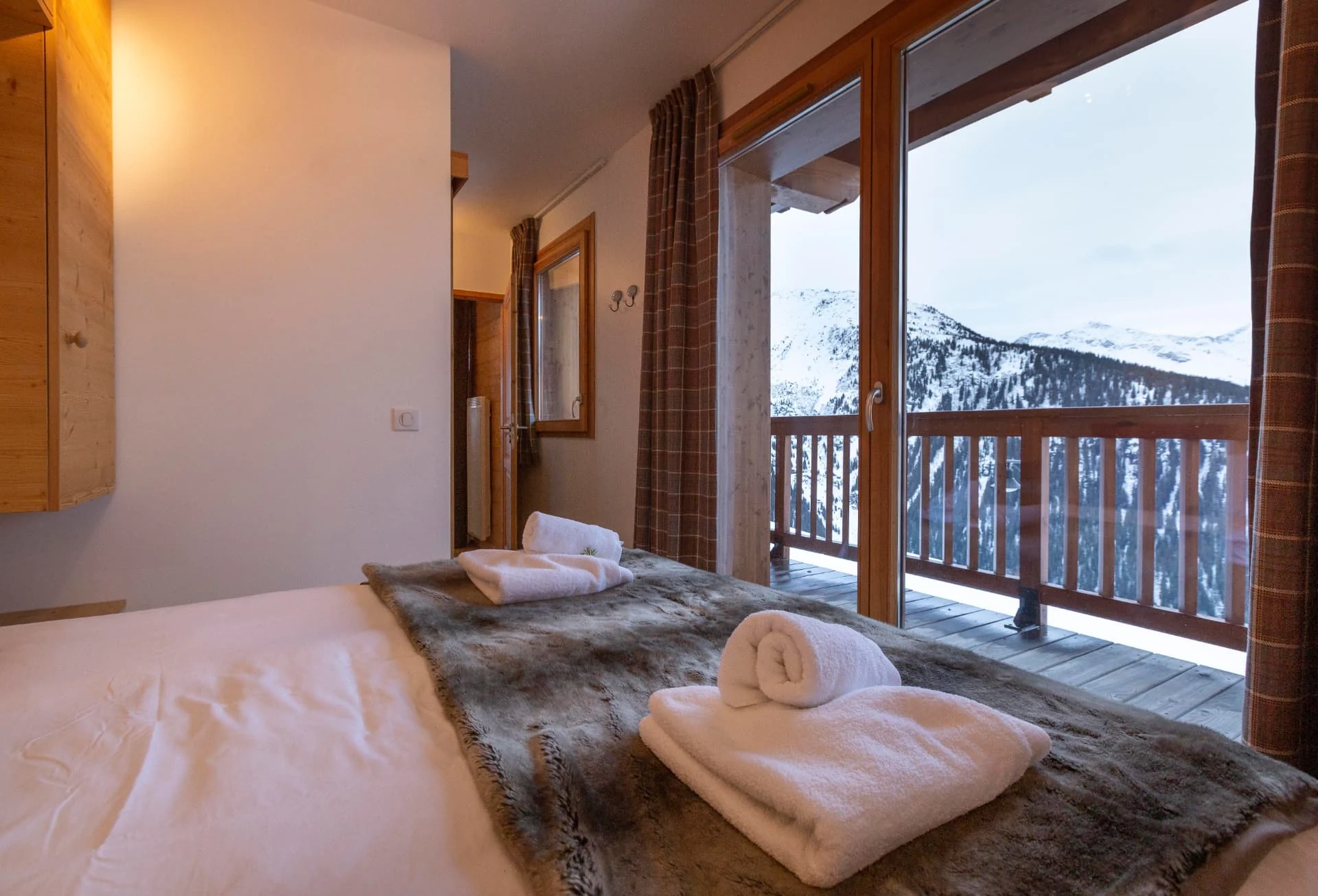Chambre de l'appartement Primavera avec accès terrasse et vue sur les montagnes enneigées