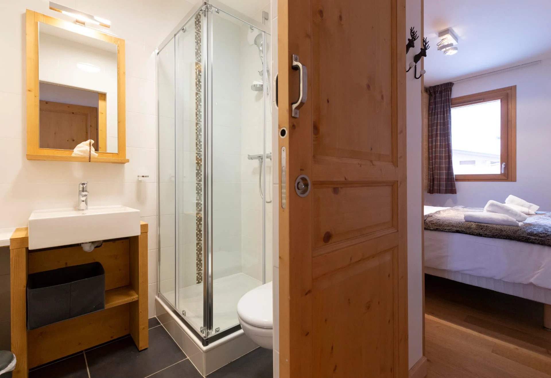 Salle de douche de l'appartement Primavera avec vasque, miroir en bois et accès chambre