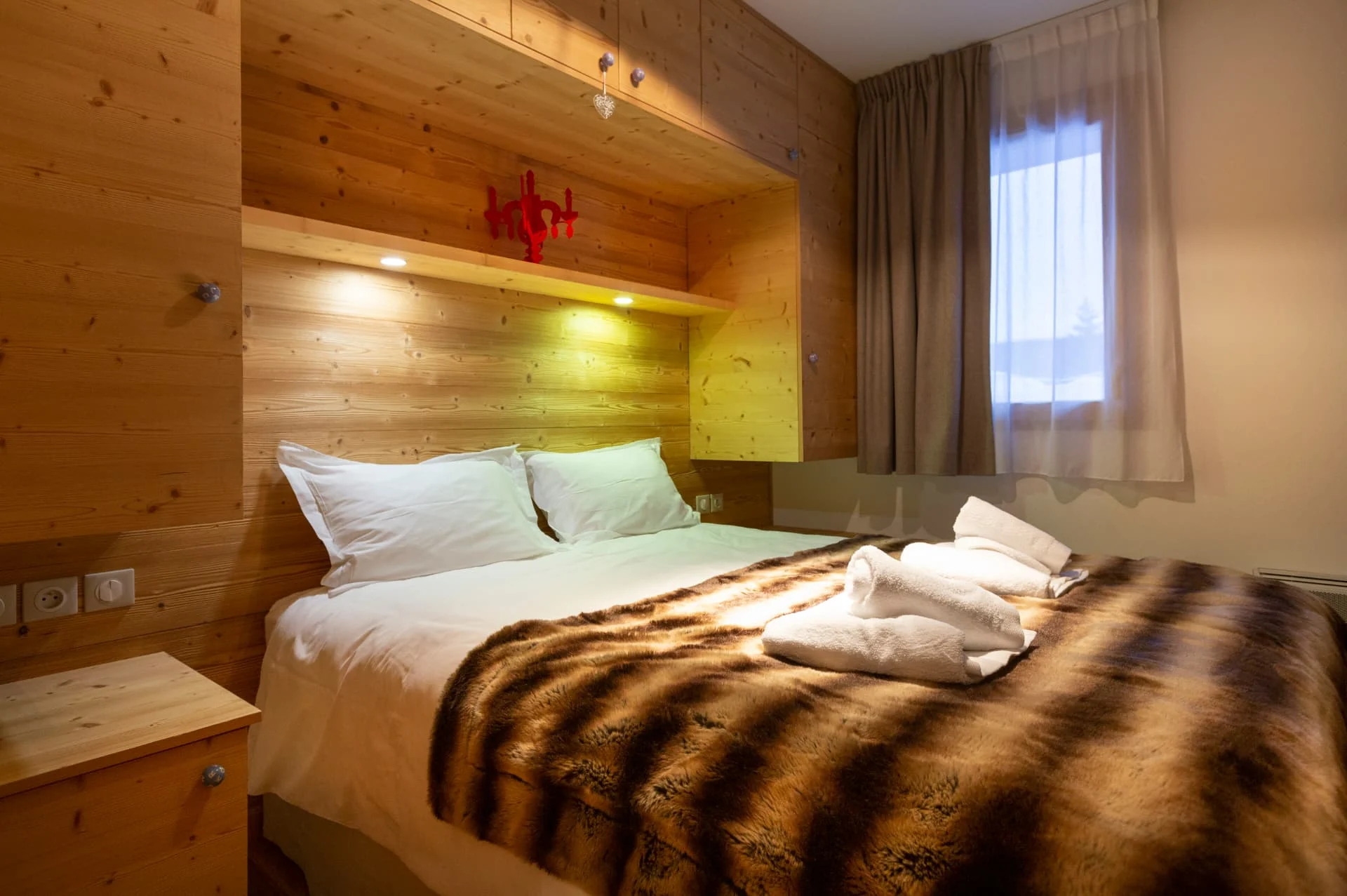 Chambre avec lit double de l'appartement Gélinotte habillée de vieux bois
