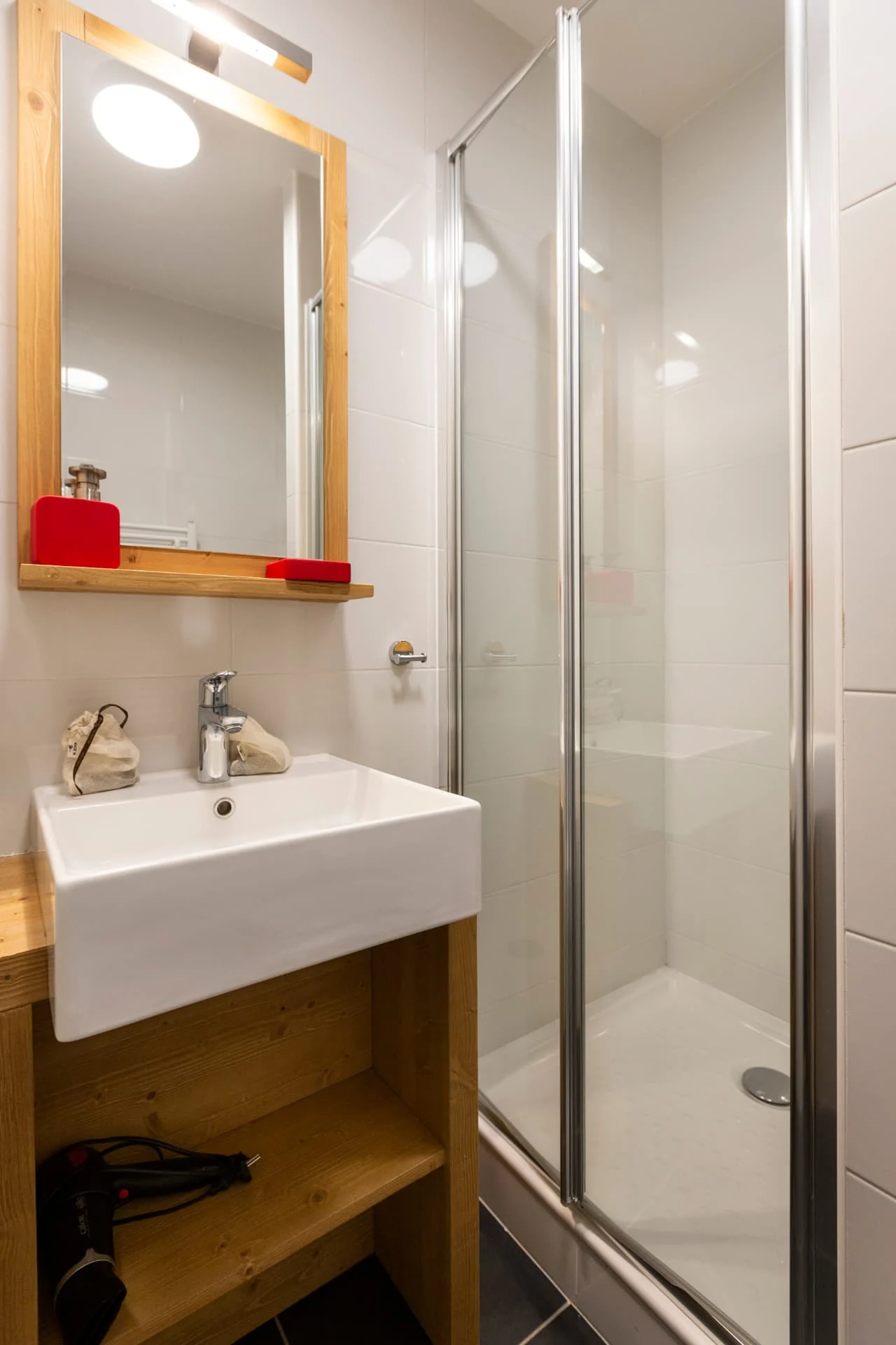 Salle de douche de l'appartement Gélinotte avec vasque et miroir en bois