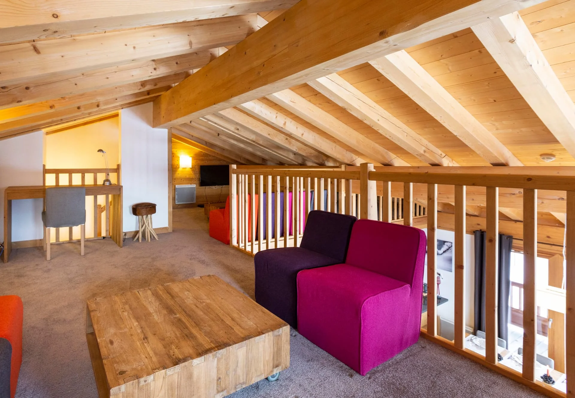 Mezzanine de l'appartement San Bernardo avec espace bureau, fauteuils colorés et télévision